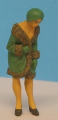 Omen - Woman wearing hat & coat, leaning forward